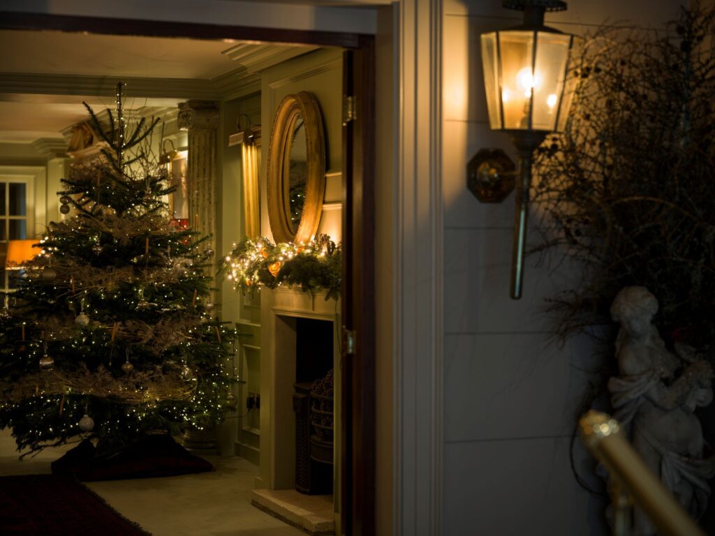 Warmly lit entrance at Batty Langley’s revealing a Christmas tree and decorated fireplace inside.